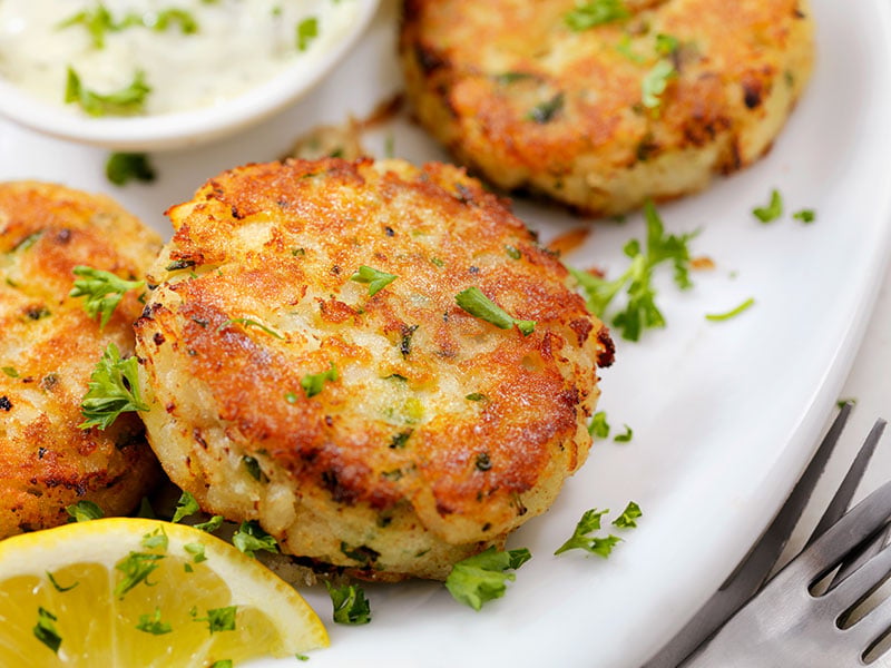 Tasty fish cakes sprinkled with herbs and served with lemon