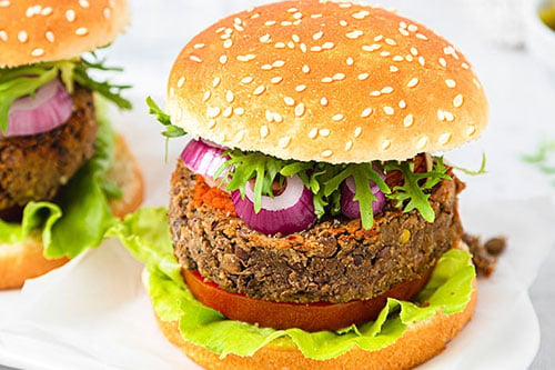 A plant based burger in a bun with salad