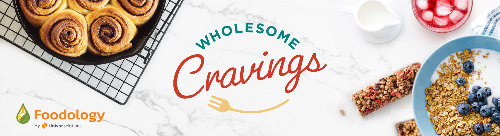 Healthier food and beverages on a marble tabletop with the Wholesome Cravings logo