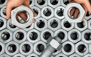Large Metal Treated nuts and bolts in a pattern and being held 