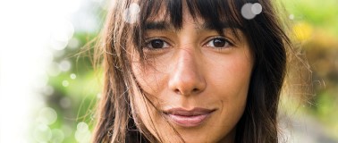 Close-up of woman standing outdoors wearing sustainable beauty products