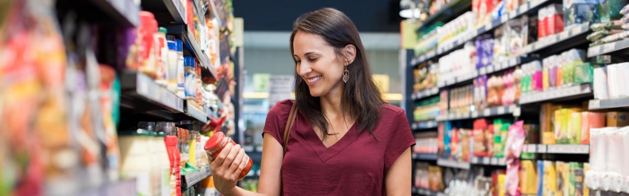 Woman in a grocery store reading nutrition labels
